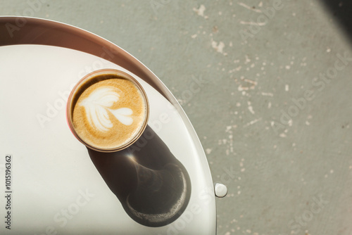Cappuccino cup with beautiful latte art on white table in cafe or coffee shop. Hot tasty drink in glass takeaway mug. take your coffee to go. eco friendly, plastic free, zero waste concept. flat lay
