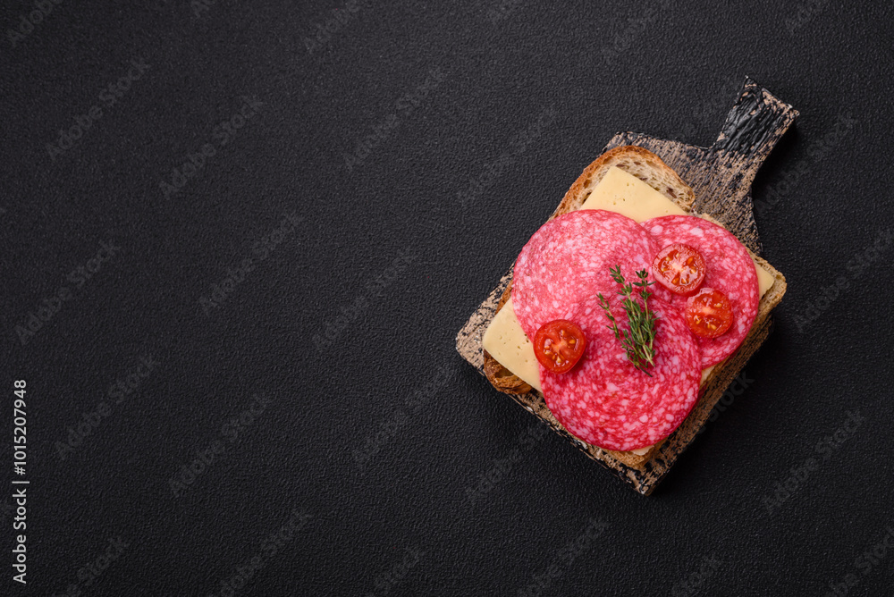 Sandwich with toast, salami slices, cheese and tomatoes, salt and spices