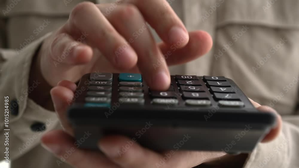 Young businessman using a calculator and laptop calculates expenses, income, money, counting bills, office documents, checking expenses, writing a business budget, accountant, financial work, calculat Young businessman using a calculator and laptop calculates expenses, income, money, counting bills, office documents, checking expenses, writing a business budget, accountant, financial work, calculat