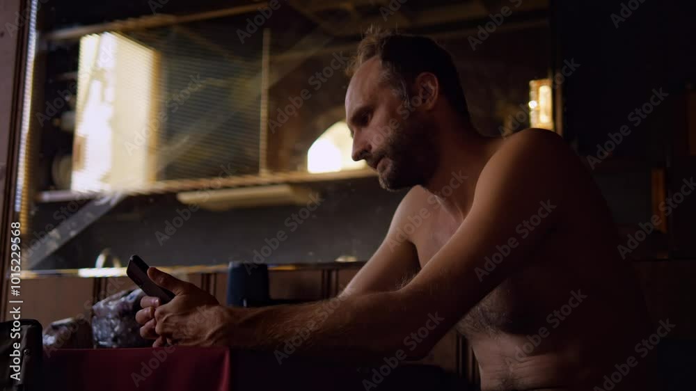An adult man paces his bedroom while having a tense and nervous conversation on his phone. His body language and facial expressions convey stress and anxiety An adult man paces his bedroom while having a tense and nervous conversation on his phone. His body language and facial expressions convey stress and anxiety