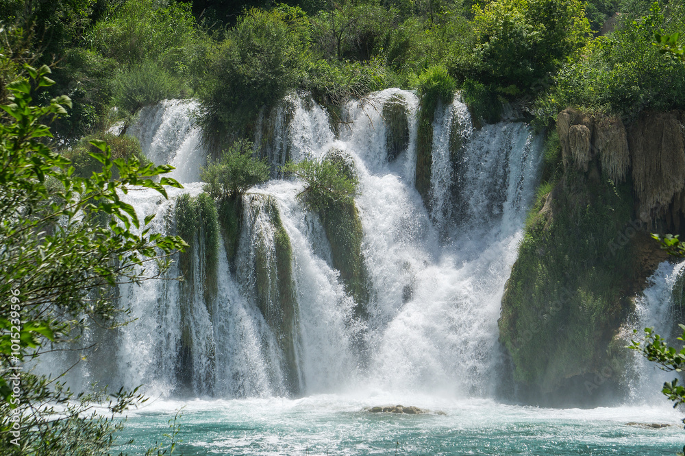 Fototapeta premium Waterfall among the green summer forest.