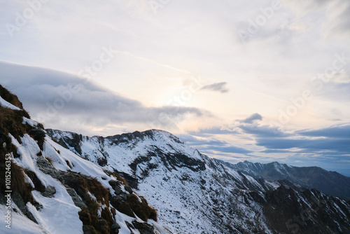 Breathtaking panorama of snow-capped mountain peaks under a stunning sky with clouds. Perfect for travel, nature, and winter themed designs. Fagaras mountains, Romania