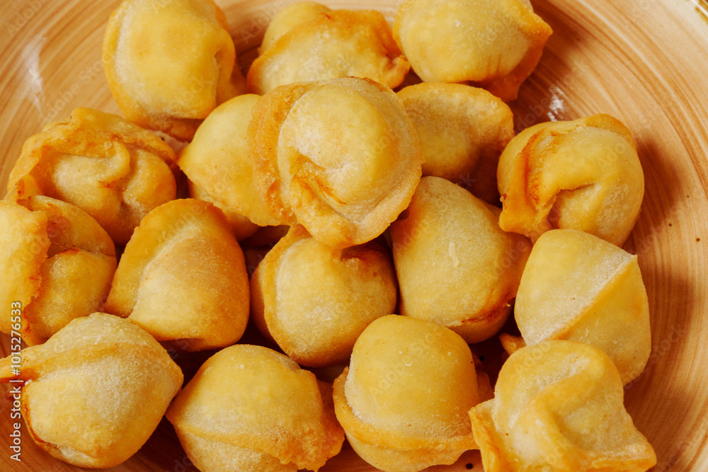 Golden dumplings arranged artfully in a wooden bowl, showcasing their crispy texture and inviting aroma on a sunny afternoon Golden dumplings arranged artfully in a wooden bowl, showcasing their crispy texture and inviting aroma on a sunny afternoon