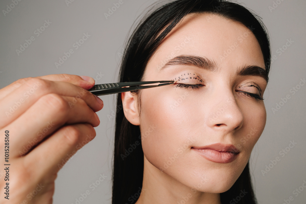 Blepharoplasty. Surgeon is checking distance in between dotted lines on eyelid with anatomical tweezers. Upper blepharoplasty marking eyelid.