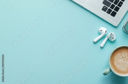 Minimalist setup with MacBook, AirPods, and a coffee on a light blue desk for a modern workspace concept photo