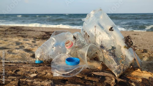 Plastic items scattered on the sandy beach by the sea. An ecological issue that we create ourselves while enjoying nature.