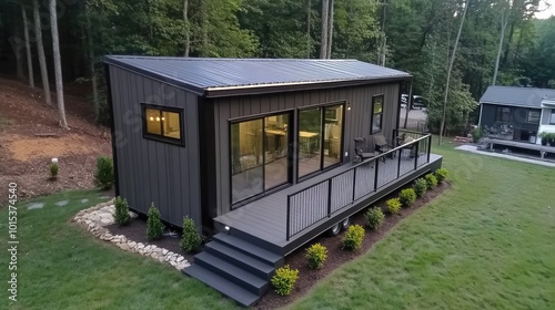 This tiny house on wheels features solar panels and a welcoming deck, nestled amidst lush greenery, inviting relaxation in a peaceful forest setting.