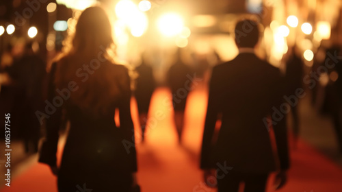 A blurry background with famous people walking the red carpet.