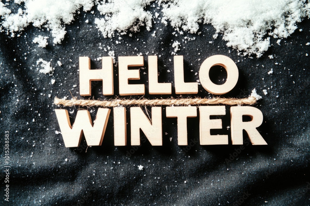 Fototapeta premium Hello winter: wooden letters on snowy black background