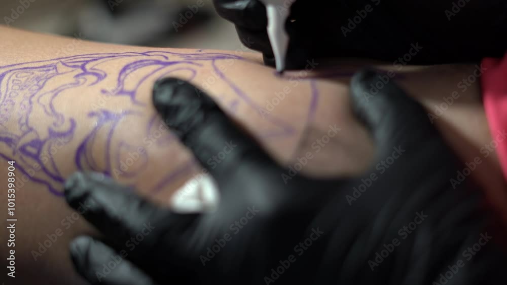 Close up of hand tattooing an oni mask over skin Close up of hand tattooing an oni mask over skin