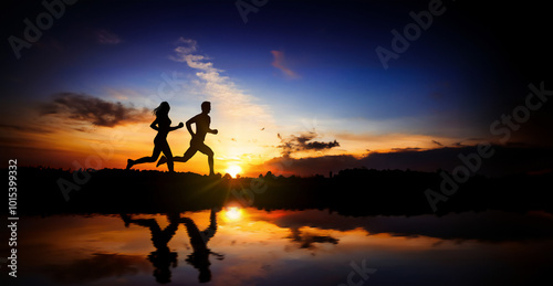 Young couple run together on a sunset