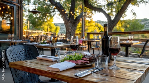 An outdoor Western food restaurant with wooden tables set for dinner, featuring steak and salad. No customers are present