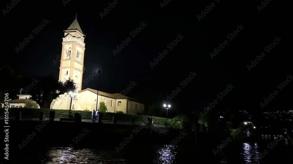 Illuminated Church Santi Pietro e Paolo at Night and the Moon on the Waterfront to Lake Lugano in Lavena, Ponte Tresa, Lombardy, Italy, Europe Illuminated Church Santi Pietro e Paolo at Night and the Moon on the Waterfront to Lake Lugano in Lavena, Ponte Tresa, Lombardy, Italy, Europe