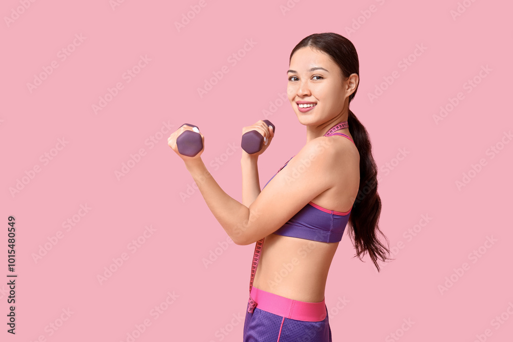 Young woman in sportswear, with measuring tape and dumbbells on pink background. Weight loss concept Young woman in sportswear, with measuring tape and dumbbells on pink background. Weight loss concept