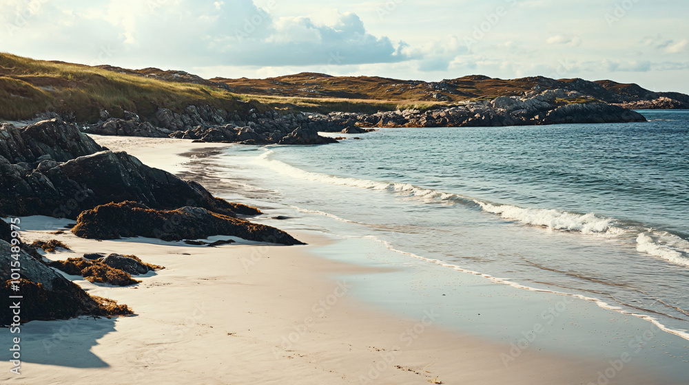 A tranquil beach with rocky outcrops and gentle waves lapping at the shore.