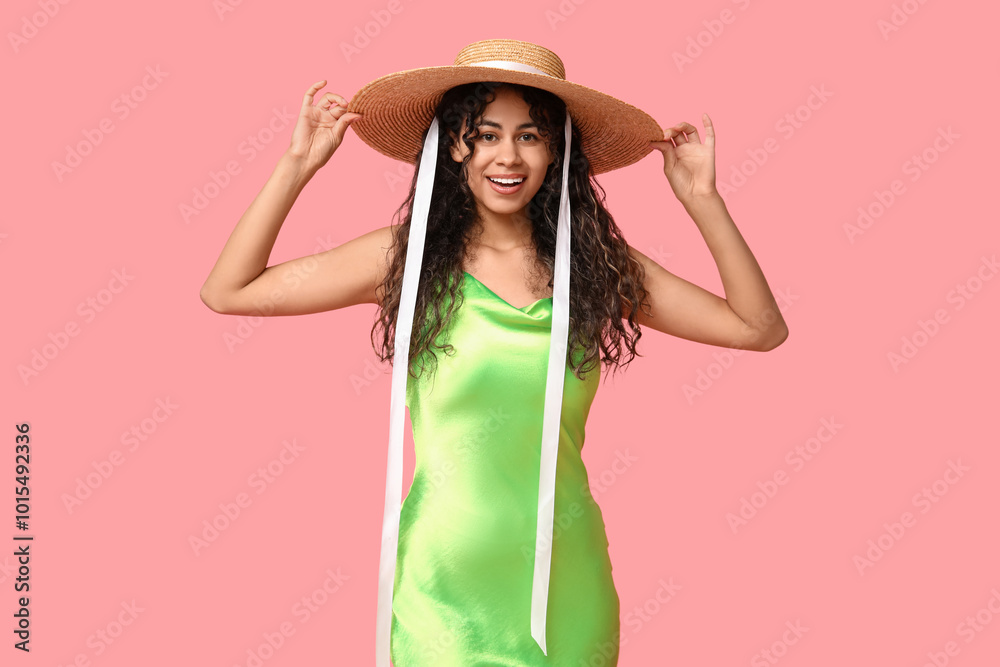 Stylish African-American woman in dress and hat on pink background Stylish African-American woman in dress and hat on pink background