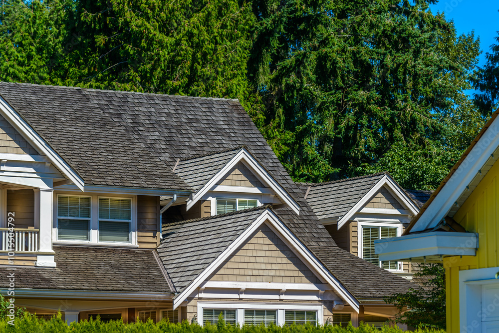 A perfect neighborhood. Houses in suburb at Fall in the north America. Top of a luxury house with nice window over blue sky. A perfect neighborhood. Houses in suburb at Fall in the north America. Top of a luxury house with nice window over blue sky.