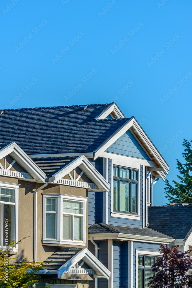 A perfect neighborhood. Houses in suburb at Fall in the north America. Top of a luxury house with nice window over blue sky.