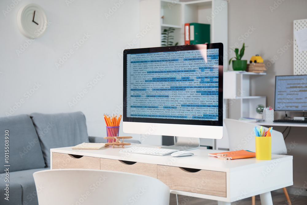 Computer monitor with code and stationery on programmer's desk in office Computer monitor with code and stationery on programmer's desk in office