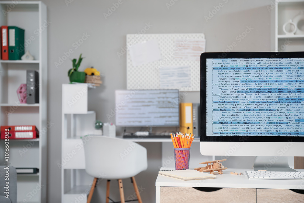 Computer monitor with code and stationery on programmer's desk in office Computer monitor with code and stationery on programmer's desk in office