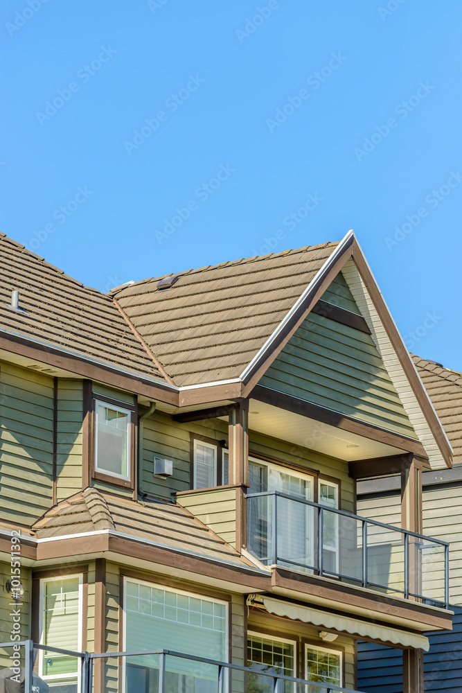 A perfect neighborhood. Houses in suburb at Fall in the north America. Top of a luxury house with nice window over blue sky. A perfect neighborhood. Houses in suburb at Fall in the north America. Top of a luxury house with nice window over blue sky.