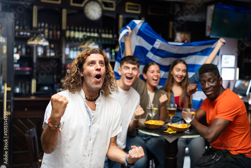 Enthusiastic Greek fans scream with joy in a beer bar. Greece win