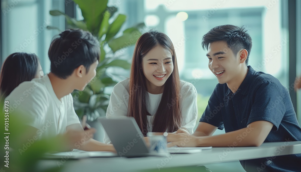 Three Young Adults Collaborating on a Laptop in a Modern Office Setting Three Young Adults Collaborating on a Laptop in a Modern Office Setting