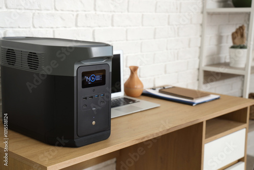 Portable power station on desk in office, closeup photo