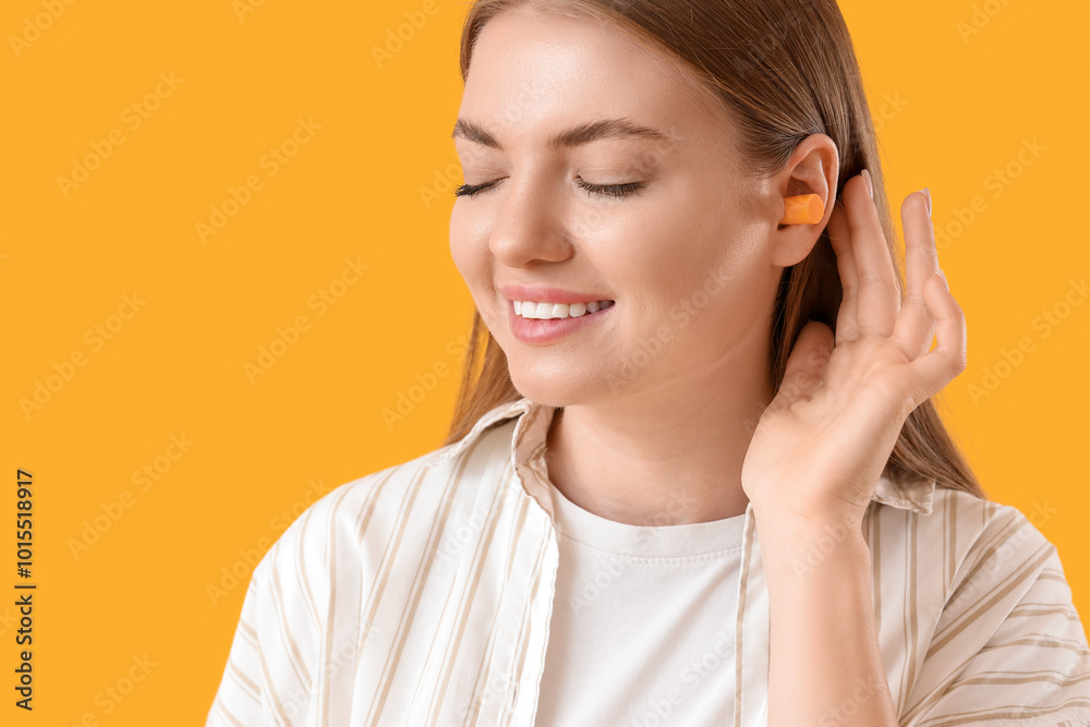 Young woman with ear plug on yellow background, closeup Young woman with ear plug on yellow background, closeup