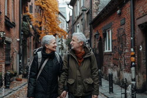 Cheerful senior couple walking in the city. They are looking at each other and smiling.