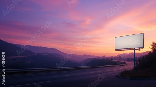 A sleek highway signboard with a blank panel stands prominently against the mountains as a winding road leads into the distance under a soft morning sky