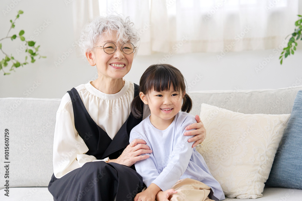 リビングで孫に寄り添う祖母 リビングで孫に寄り添う祖母