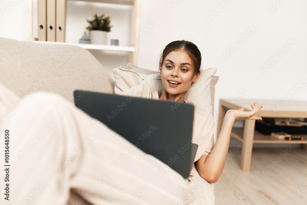 Happy Laptop Connection: A Smiling Woman Typing on a Modern Device in the Comfort of her Cozy Living Room Happy Laptop Connection: A Smiling Woman Typing on a Modern Device in the Comfort of her Cozy Living Room