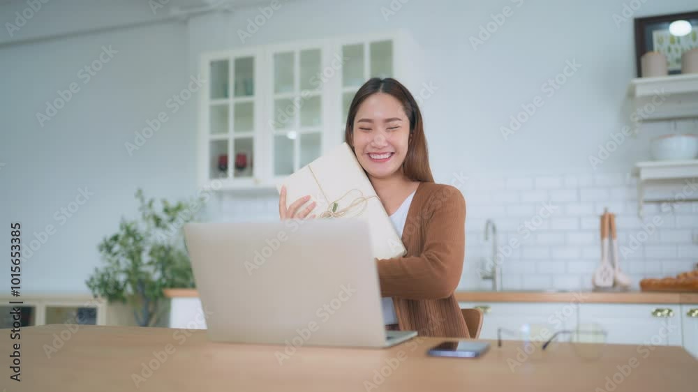 Young asian woman using computer laptop at home. Female showing gift box while on video conversation with friend. Happy birthday, Happy new year, Thanksgiving day Young asian woman using computer laptop at home. Female showing gift box while on video conversation with friend. Happy birthday, Happy new year, Thanksgiving day