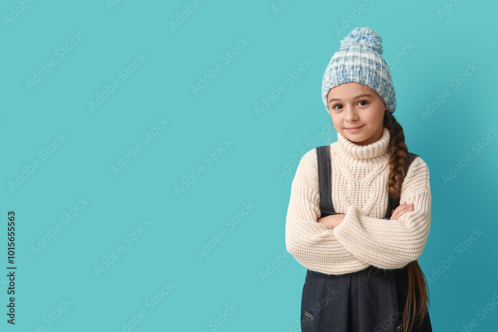 Cute little girl in warm hat on blue background Cute little girl in warm hat on blue background
