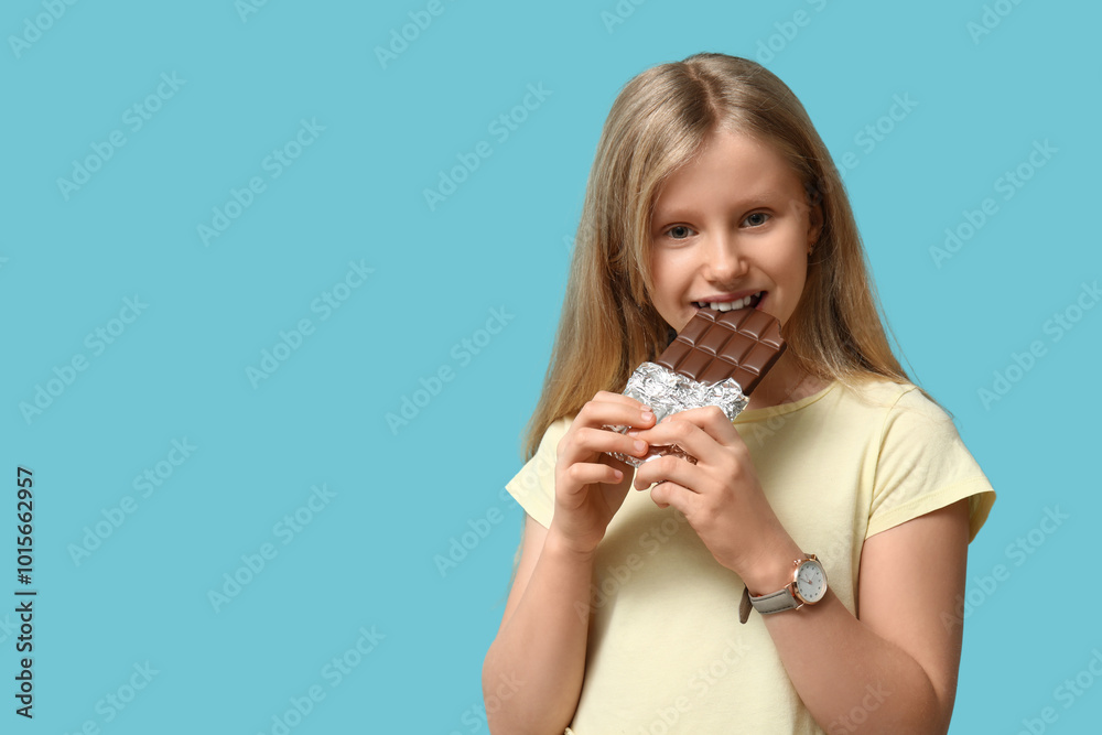 Happy little girl with sweet chocolate bar on blue background Happy little girl with sweet chocolate bar on blue background