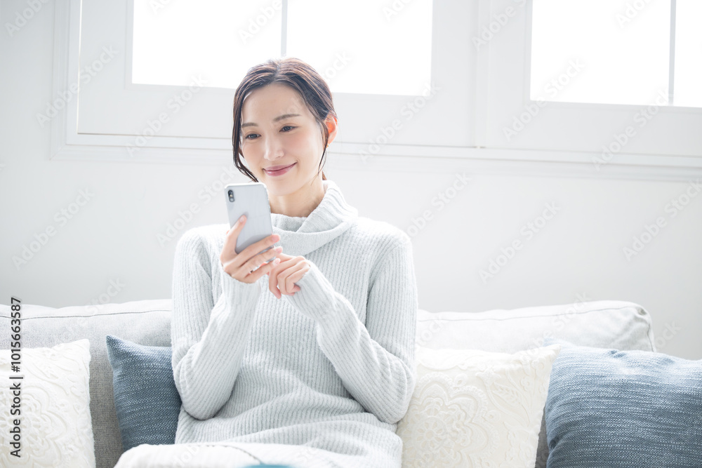 Woman in winter knit tapping looking at phone Winter ice blue Woman in winter knit tapping looking at phone Winter ice blue