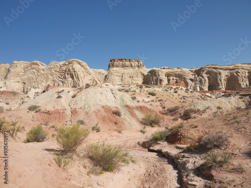 Hiking in Vermilion Cliffs arid desert landscape with eroded rocks on sunny day with clear blue sky, Utah