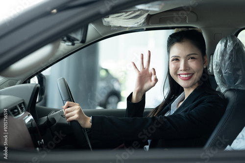 Woman Gesturing OK Sign Inside The Car At Showroom