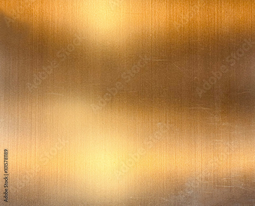 Foto Gold metallic stainless steel sheet in hairline brushed pattern with shades of lights and reflection effects