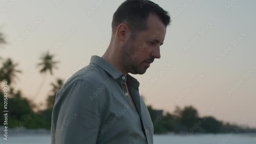 Parallax shot of thoughtful man standing in silence on the beach contemplating about life and past during epic sunset. Parallax shot of thoughtful man standing in silence on the beach contemplating about life and past during epic sunset.