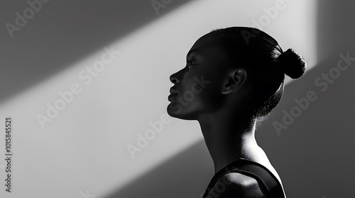 A moody black and white image of a model standing against a plain background, with dramatic high-contrast lighting casting long shadows behind. 8k UHD, suitable for high-quality printing or 