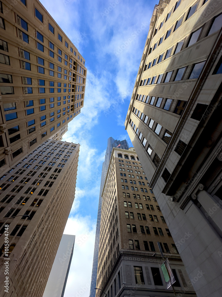 Fototapeta premium Worm's-Eye View of San Francisco Financial District: Modern and Historical Architecture Under Clear Skies with Light Clouds Drifting. 