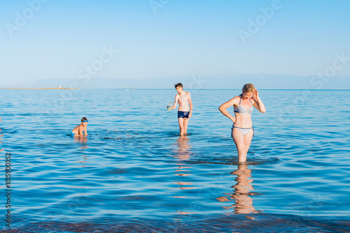 Mom and two sons swim in the sea