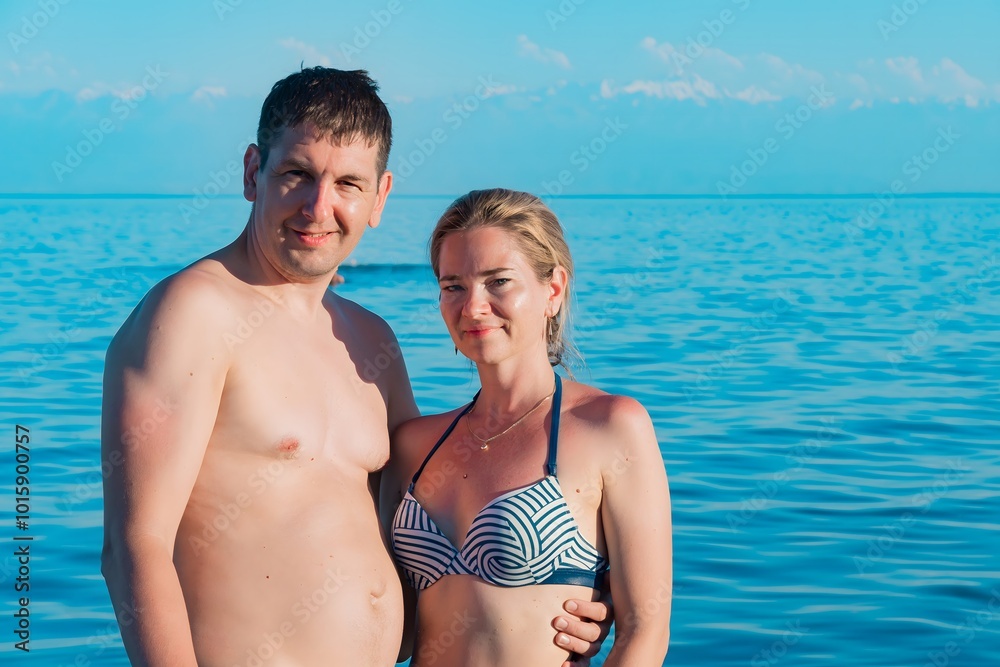 A couple on the background of the turquoise sea and mountains A couple on the background of the turquoise sea and mountains
