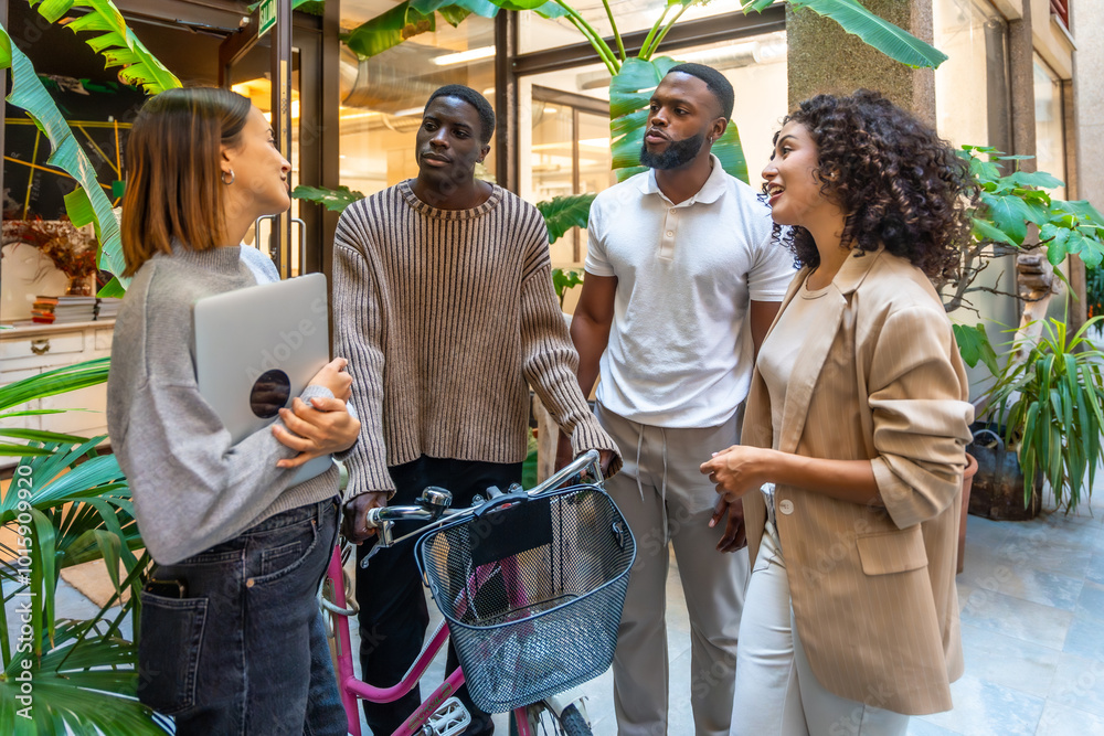 Man arriving at the office with bike talking with coworkers Man arriving at the office with bike talking with coworkers