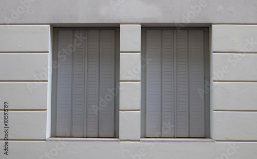 Modern building wall with two sliding shutter windows, featuring minimalist architectural style and clean lines. photo