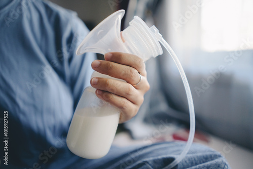 Foto Mother hands showing breast milk inside bottle after pumping