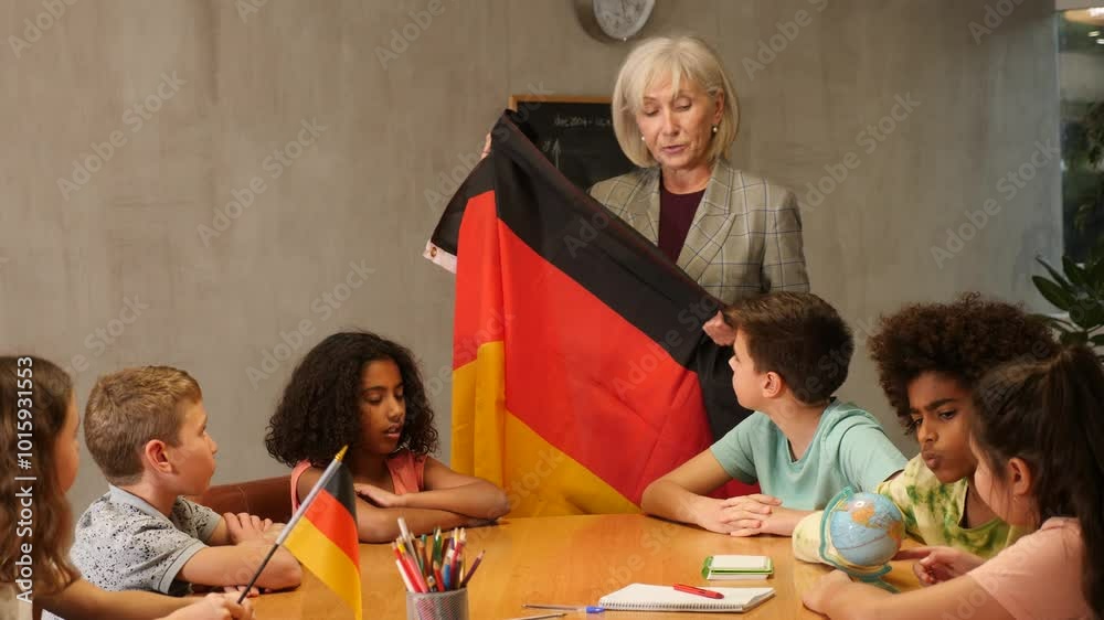 Friendly high school female teacher tells pupils the history of Germany ...