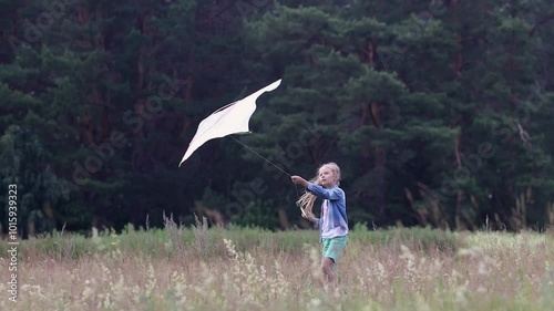 Summer holidays in the village.Active outdoor weekend.The concept of a carefree childhood.A girl launches a kite in a field.Weekends with children and children's leisure